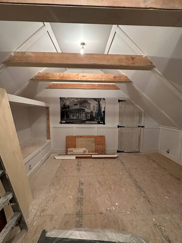 Before: vaulted attic ceiling with exposed beams and TV placement template