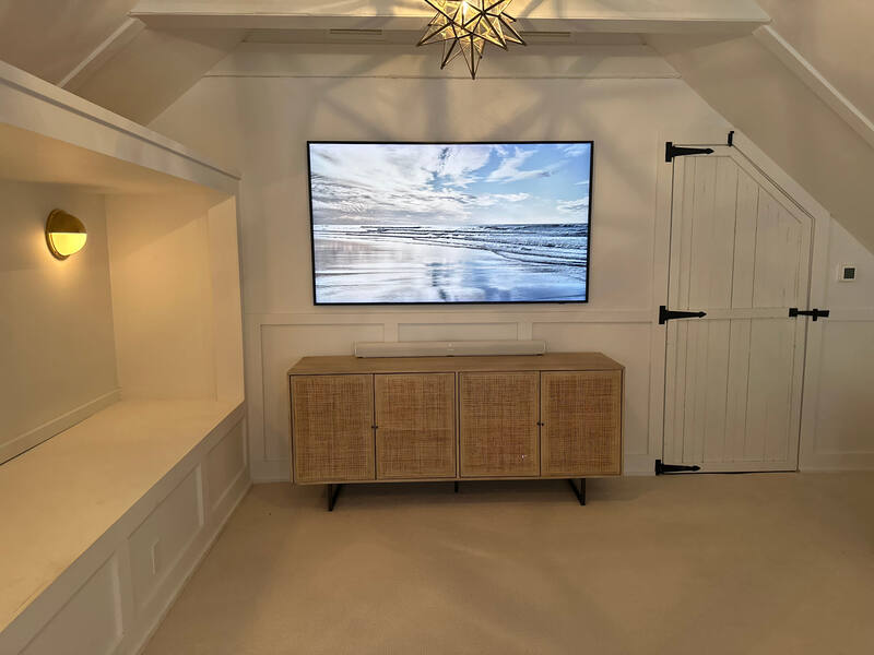 Angled view of TV, credenza, and sconce lighting