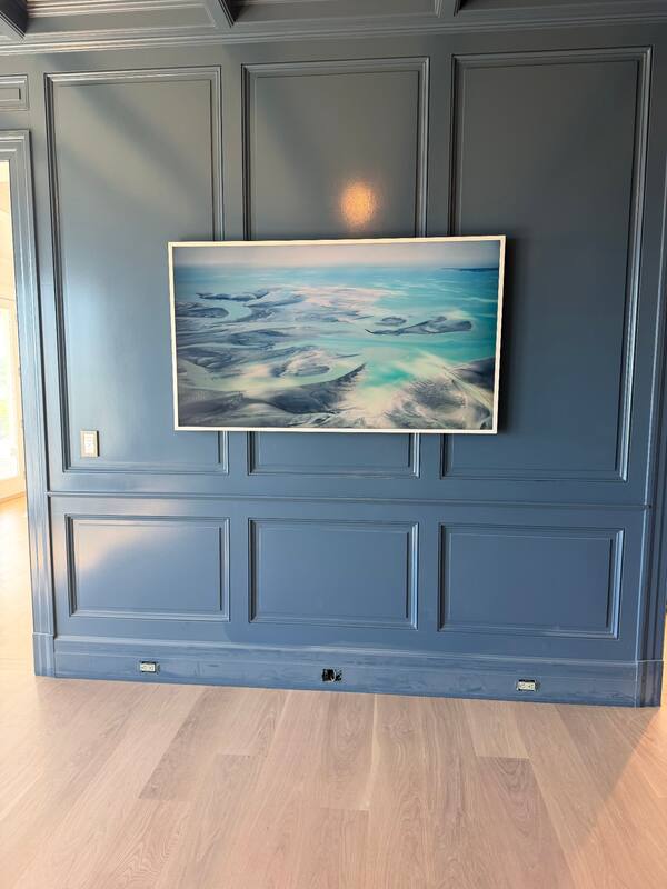 Samsung Frame TV on deep blue paneled wall in art mode