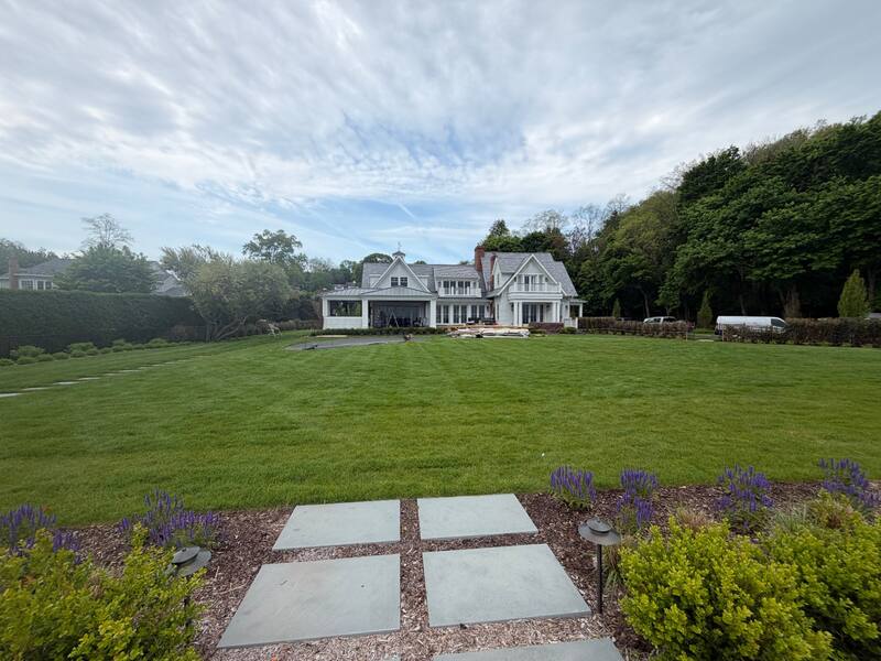 Wide view of the estate from the back garden path with lavender beds and bluestone pavers leading to the porch