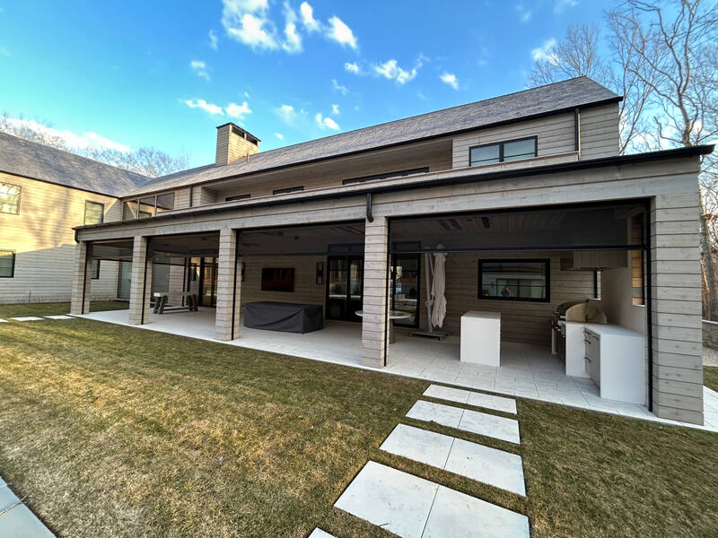 Rear exterior with covered outdoor living area and integrated entertainment wall