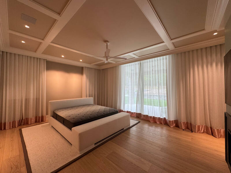 Coffered ceiling, soft lighting, and full-height drapery