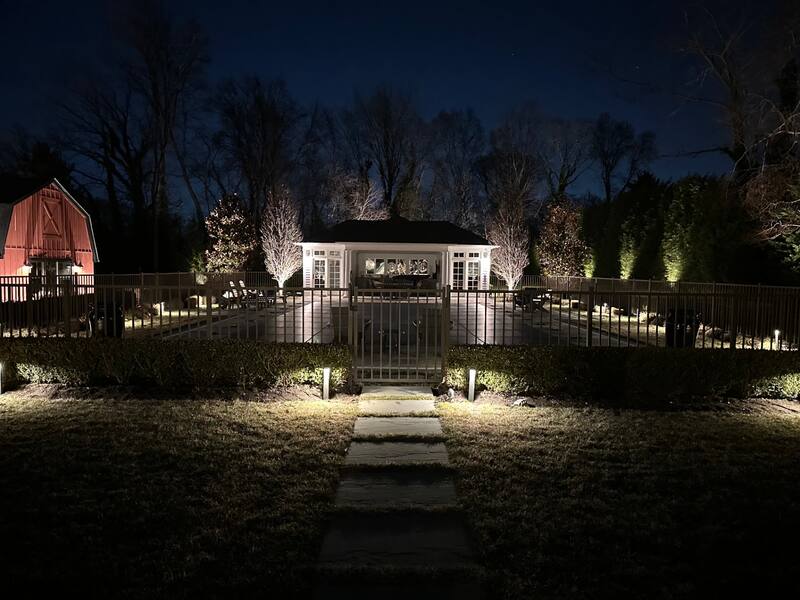Lit pool house and pavilion with stepping-stone path lighting