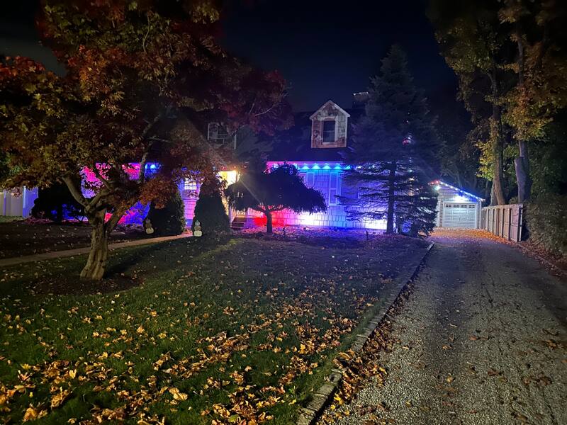 Home and detached garage with coordinated multi-color roofline lighting