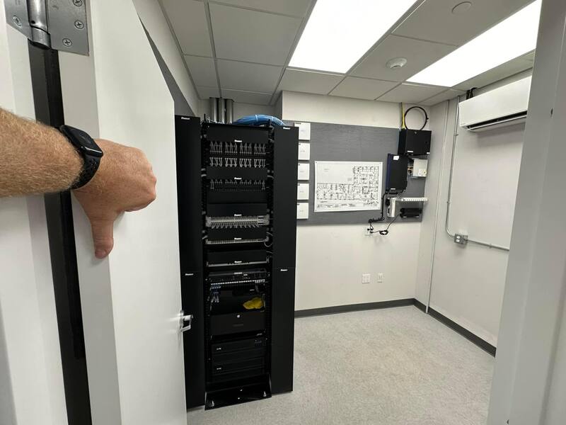 Finished MDF with Panduit rack, patch panels, switches, APC UPS, and mini-split cooling